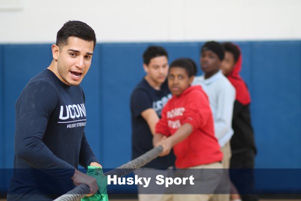 phd student, michael corral playing tug of war with students in hartford